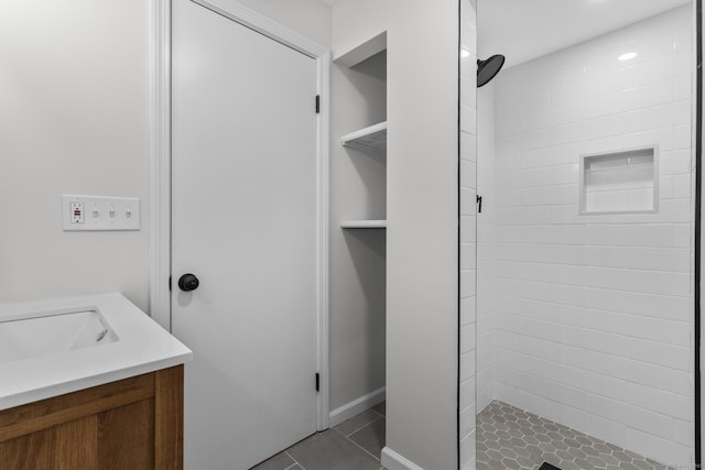 full bath featuring tile patterned flooring, a shower stall, and vanity