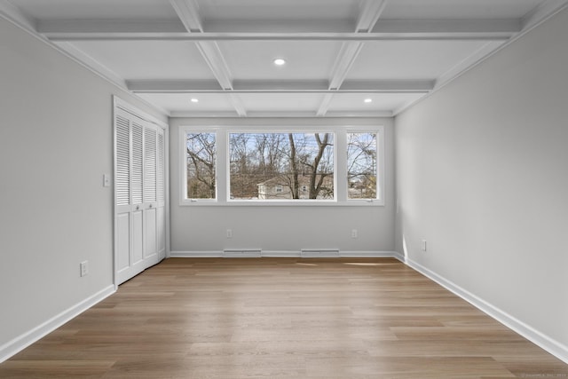 interior space featuring beamed ceiling, baseboards, coffered ceiling, and light wood-style flooring