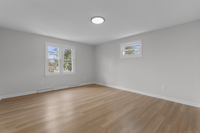 spare room with light wood-type flooring, baseboards, and a baseboard radiator