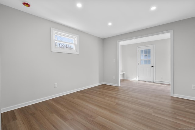 spare room with recessed lighting, baseboards, and light wood finished floors