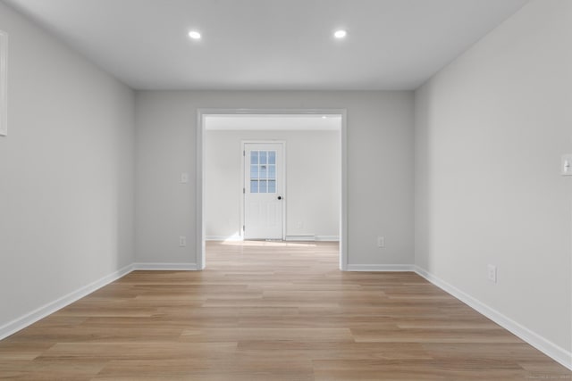 empty room with recessed lighting, light wood-style floors, and baseboards