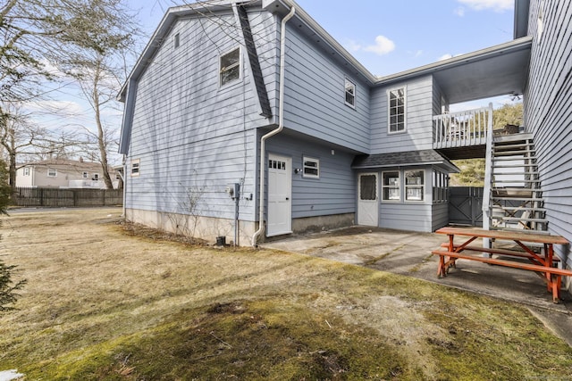 rear view of house with a patio, stairs, and fence