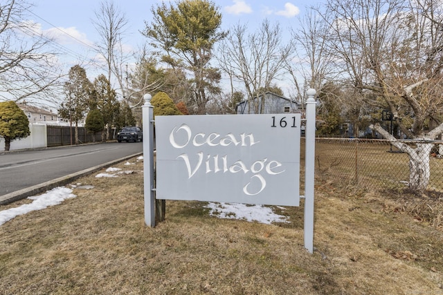 community / neighborhood sign with fence