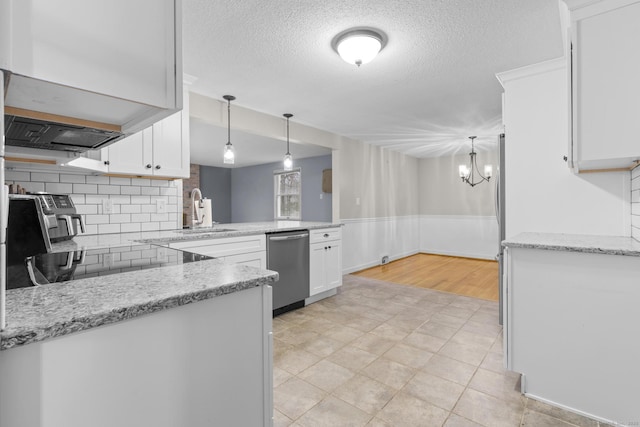 kitchen featuring stainless steel dishwasher, white cabinets, decorative light fixtures, and a wainscoted wall