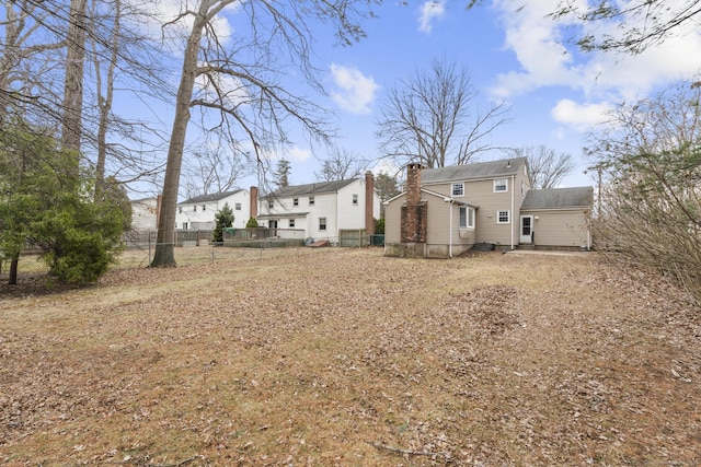 rear view of house featuring fence