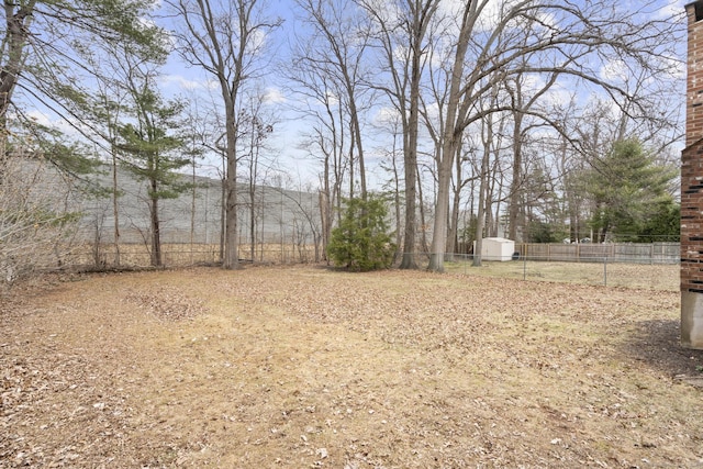 view of yard with a storage shed, an outdoor structure, and fence