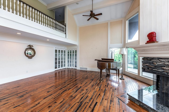 living room with a high ceiling, hardwood / wood-style floors, ceiling fan, and beam ceiling