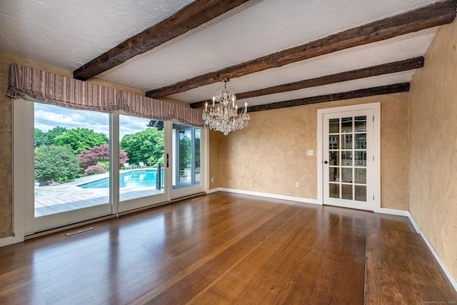 unfurnished dining area featuring beamed ceiling, hardwood / wood-style floors, a textured ceiling, and a notable chandelier