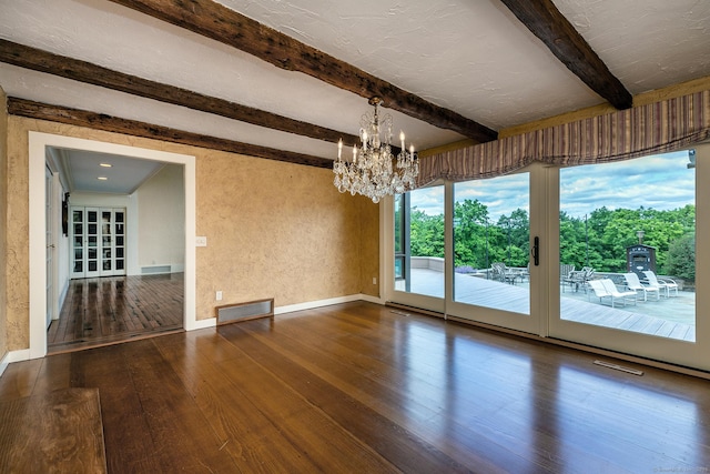 unfurnished dining area featuring hardwood / wood-style flooring, a notable chandelier, a textured ceiling, and beamed ceiling