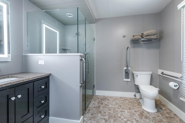 bathroom featuring vanity, toilet, and a shower with shower door