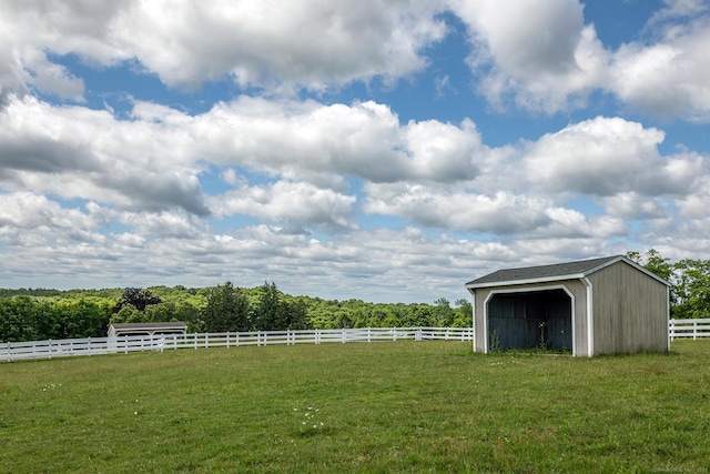 view of yard with an outbuilding and a rural view