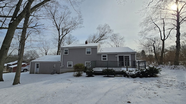 snow covered house with a wooden deck