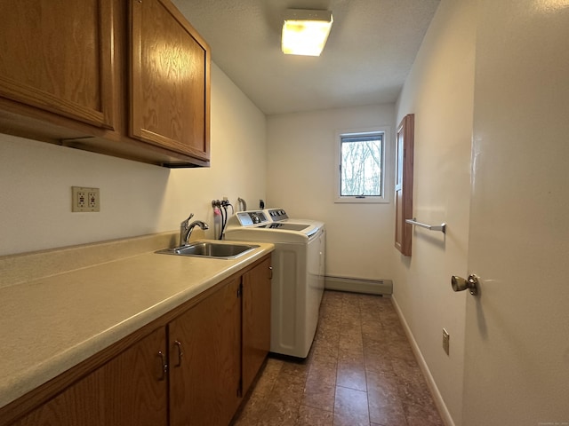 washroom with cabinets, sink, washer and clothes dryer, and baseboard heating