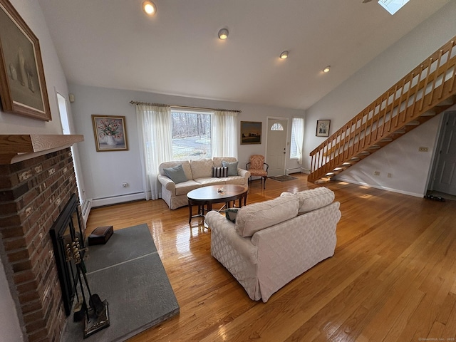 living room with lofted ceiling, light wood-type flooring, and a brick fireplace