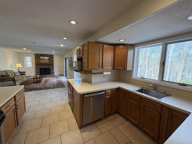 kitchen with stainless steel appliances, plenty of natural light, sink, and a brick fireplace