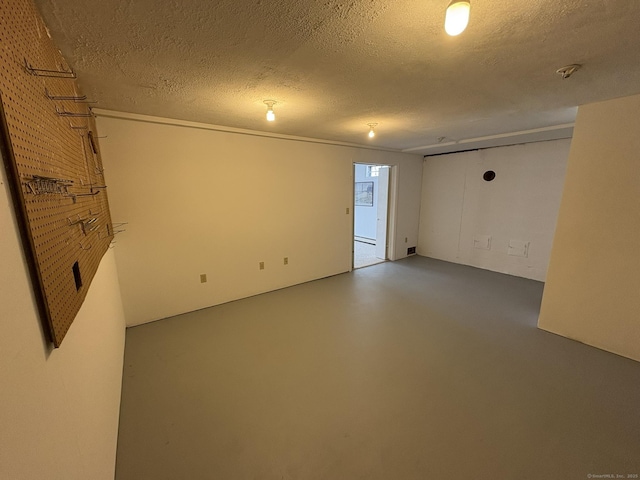 empty room with concrete floors and a textured ceiling