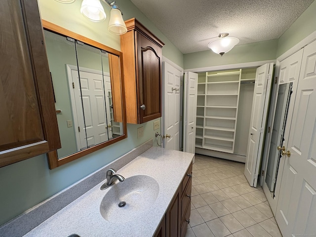 bathroom featuring tile patterned floors, a textured ceiling, and vanity