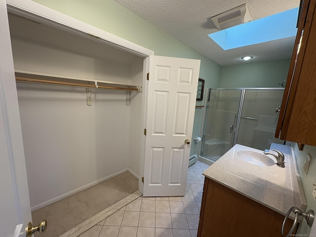 bathroom with walk in shower, a skylight, a textured ceiling, tile patterned flooring, and a baseboard heating unit