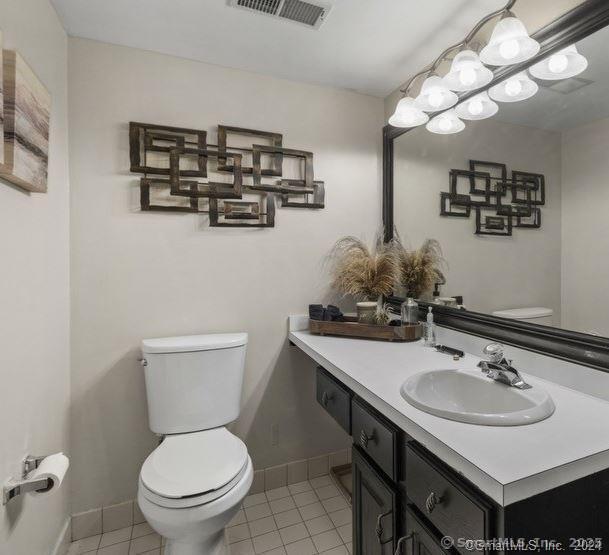 bathroom featuring tile patterned flooring, vanity, and toilet