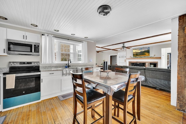 kitchen featuring stainless steel appliances, white cabinetry, sink, and light hardwood / wood-style flooring