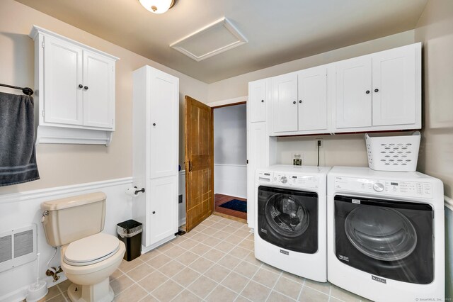 laundry area with heating unit, washer and dryer, and light tile patterned floors