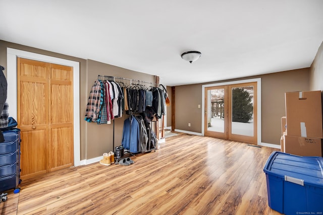 bedroom featuring access to exterior, light hardwood / wood-style floors, and french doors