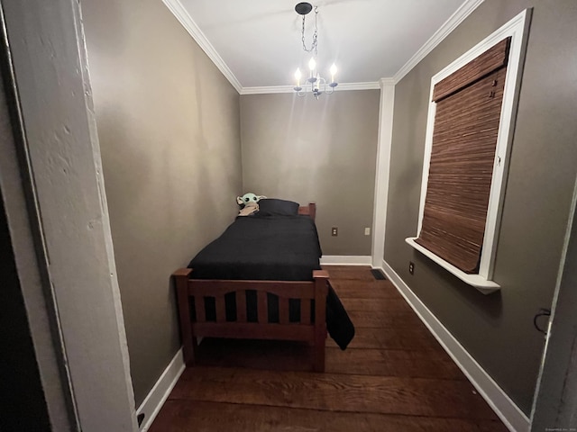 bedroom featuring dark wood-type flooring, ornamental molding, and a chandelier