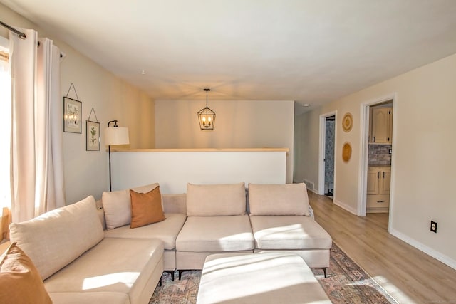 living room with an inviting chandelier and light hardwood / wood-style floors