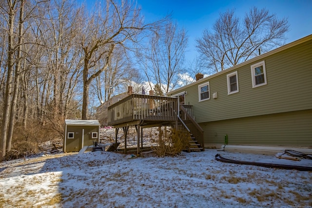 snow covered property with a deck and a shed