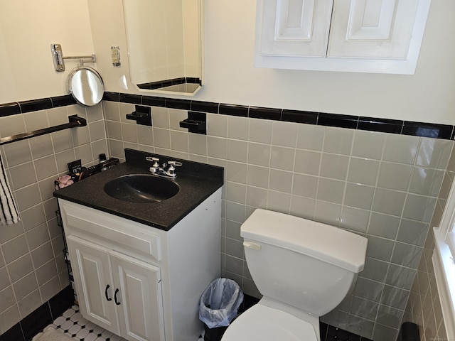 bathroom featuring vanity, tile walls, tile patterned floors, and toilet