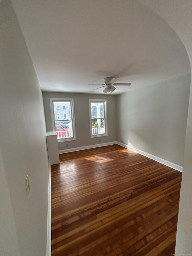 spare room featuring dark wood-type flooring and ceiling fan