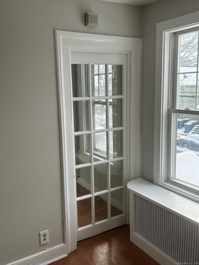 doorway with dark wood-type flooring and radiator