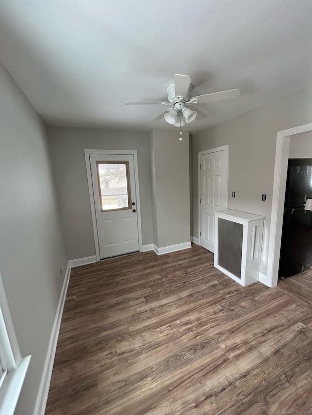 unfurnished living room with dark wood-type flooring and ceiling fan