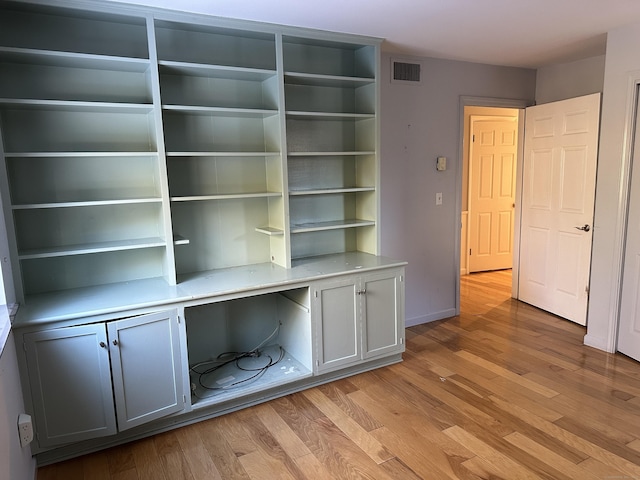 unfurnished office featuring light hardwood / wood-style flooring and built in desk