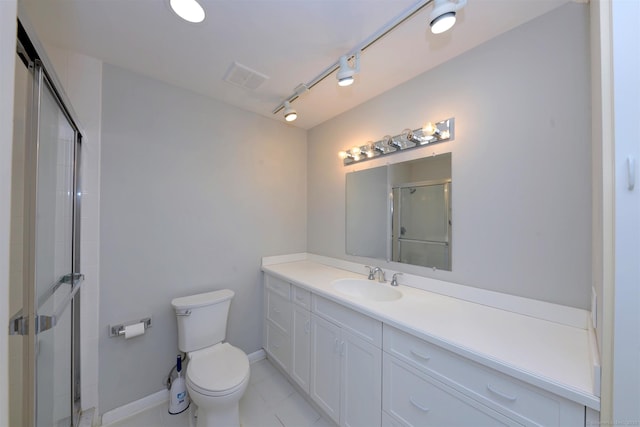 bathroom featuring rail lighting, vanity, toilet, and a shower with shower door