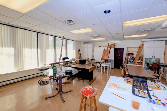 interior space featuring a baseboard heating unit and a paneled ceiling