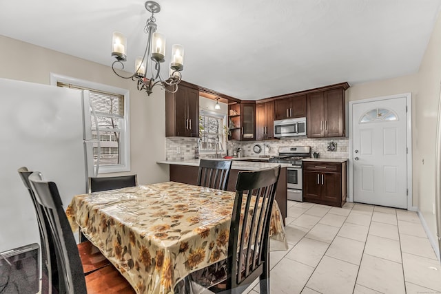 tiled dining area featuring an inviting chandelier and sink