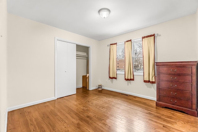 unfurnished bedroom with a closet and light hardwood / wood-style flooring