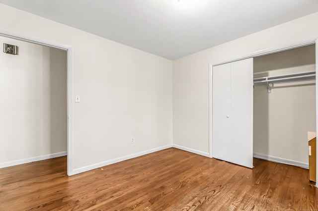 unfurnished bedroom with wood-type flooring and a closet