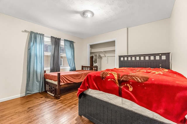 bedroom featuring hardwood / wood-style floors and a spacious closet