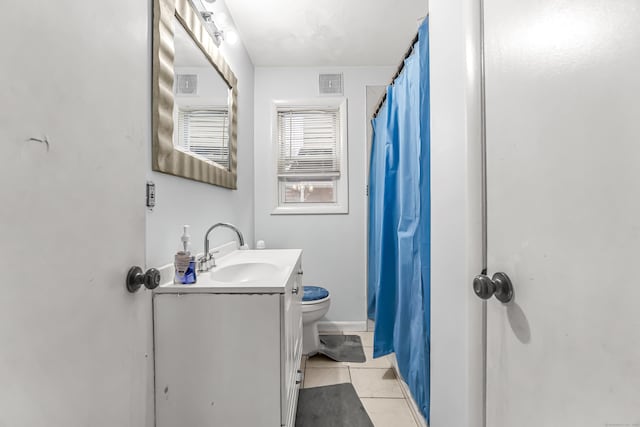 bathroom featuring tile patterned flooring, vanity, walk in shower, and toilet