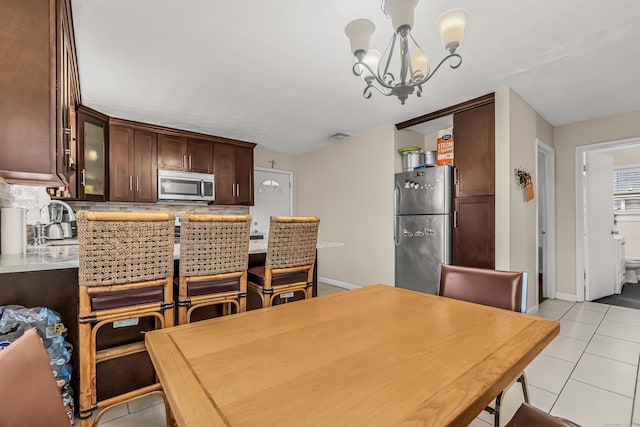 dining space featuring sink, a chandelier, and light tile patterned flooring