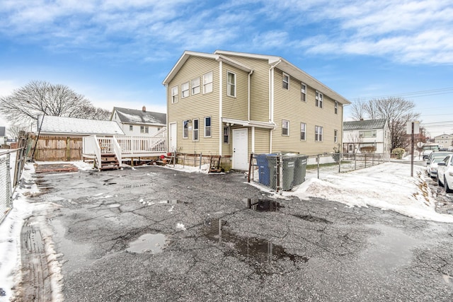 snow covered property with a wooden deck and central AC unit