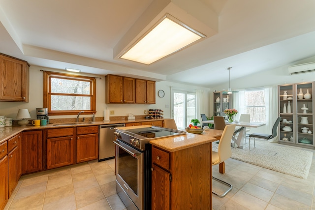 kitchen featuring sink, appliances with stainless steel finishes, plenty of natural light, a kitchen island, and decorative light fixtures