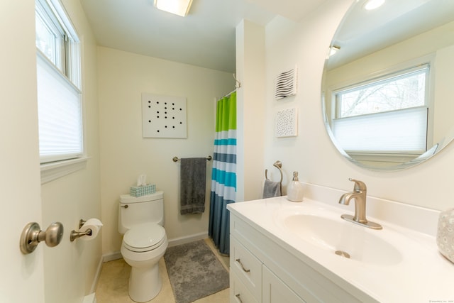 bathroom featuring tile patterned flooring, vanity, a healthy amount of sunlight, and toilet