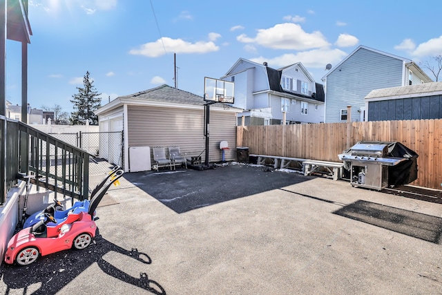 view of patio with a garage, an outdoor structure, and a grill