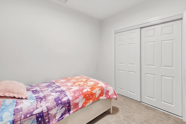 bedroom featuring light colored carpet and a closet