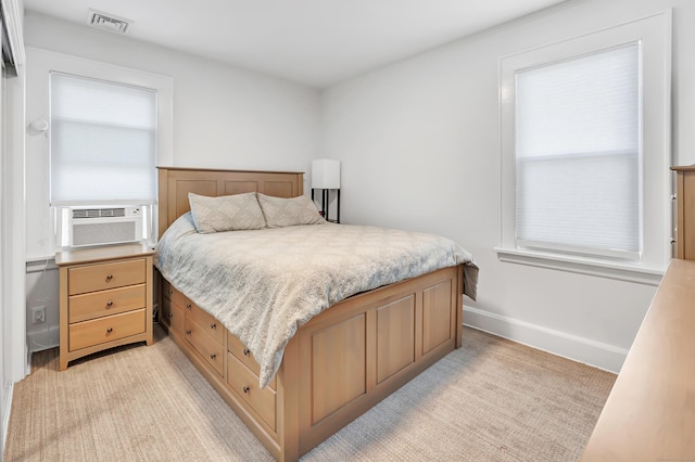 bedroom featuring cooling unit and light colored carpet