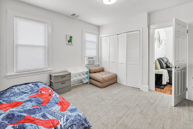 carpeted bedroom with cooling unit and a closet