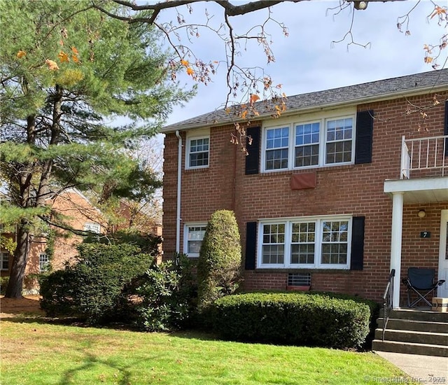 view of front of home featuring a balcony and a front yard